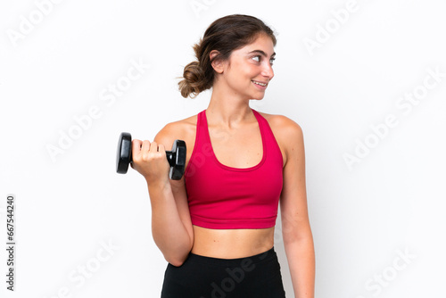 Young sport caucasian woman making weightlifting isolated on white background looking side