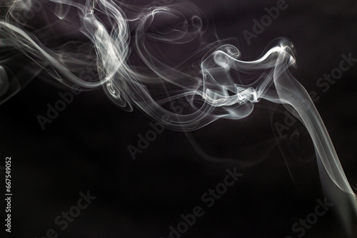 Fancy beautiful shapes from smoke in the air on a black background 