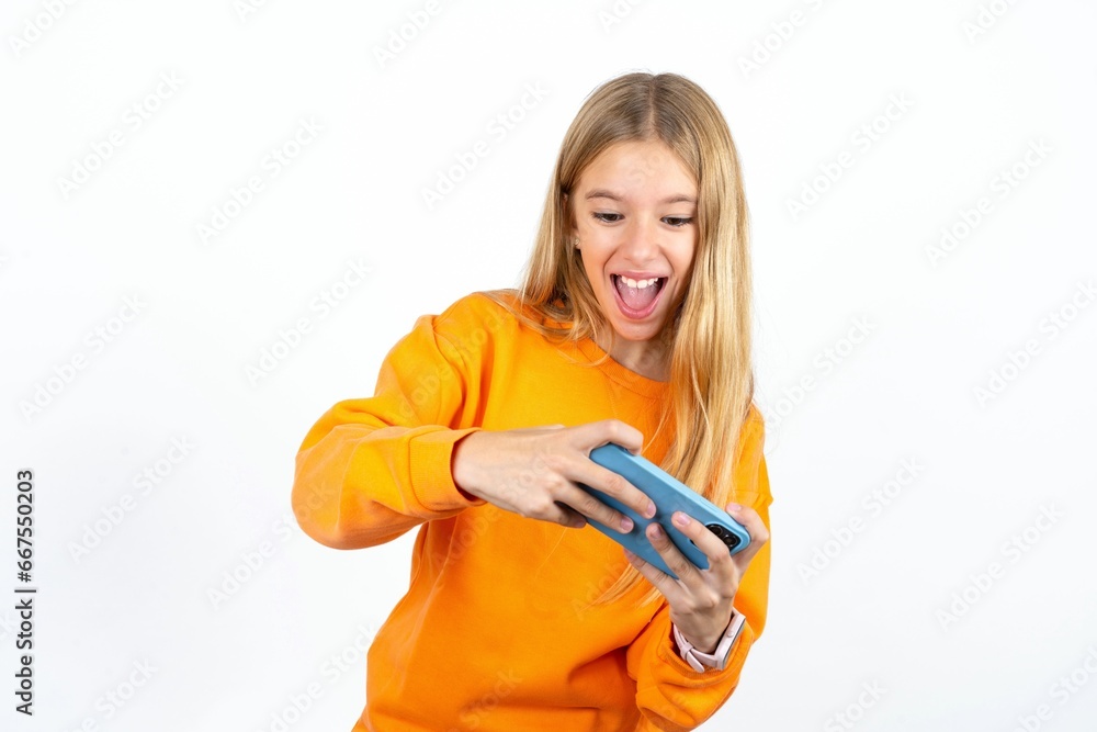 Portrait of an excited Beautiful teen girl playing games on mobile phone. Portrait of an excited Beautiful teen girl playing games on mobile phone.