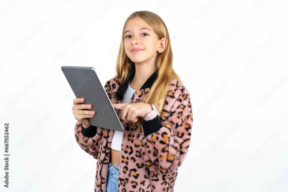 Photo of happy cheerful smart Beautifu blonde kid girl hold tablet browsing internet Photo of happy cheerful smart Beautifu blonde kid girl hold tablet browsing internet