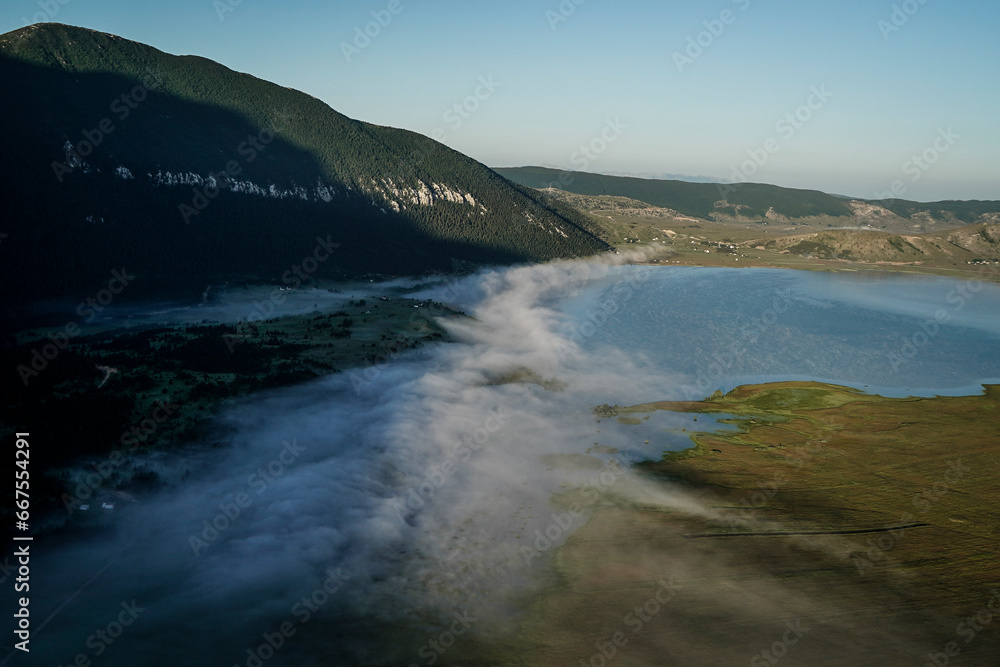 Aerial view of the foggy Blidinje Jezero lake coastline in Bosnia and Herzegovina. Aerial view of the foggy Blidinje Jezero lake coastline in Bosnia and Herzegovina.