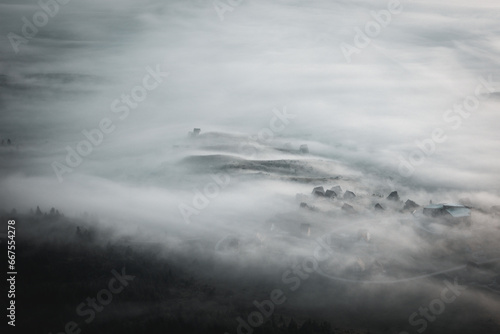 Aerial view of a foggy valley during sunrise next to town Kupres in Bosnia and Herzegovina. photo