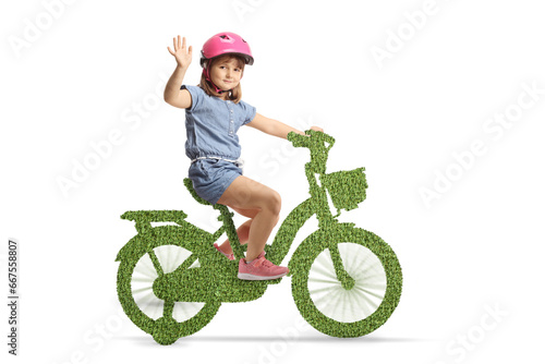 Girl with a helmet riding a green eco bicycle and waving © Ljupco Smokovski