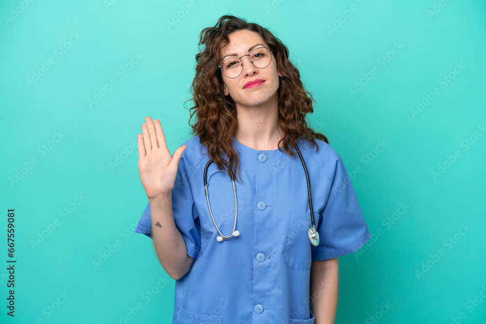 Young nurse caucasian woman isolated on blue background saluting with hand with happy expression Young nurse caucasian woman isolated on blue background saluting with hand with happy expression