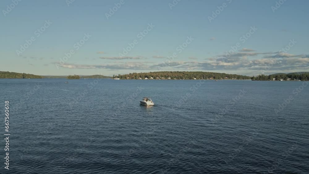 Aerial view of boat motoring in lake Winnipesaukee during sunset, New hampshire, USA. Aerial view of boat motoring in lake Winnipesaukee during sunset, New hampshire, USA.