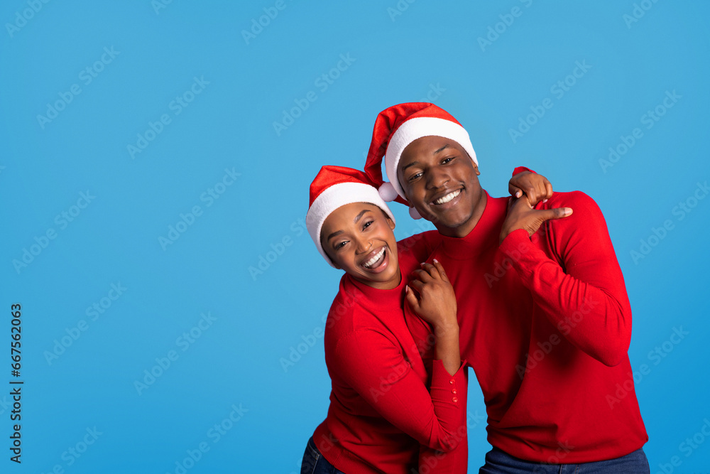 Joyful African Husband and Wife in Santa Hats Embracing, Studio Joyful African Husband and Wife in Santa Hats Embracing, Studio
