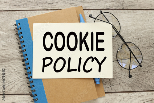 Cookie policy notebook with a blue stripe and glasses on the notebook.