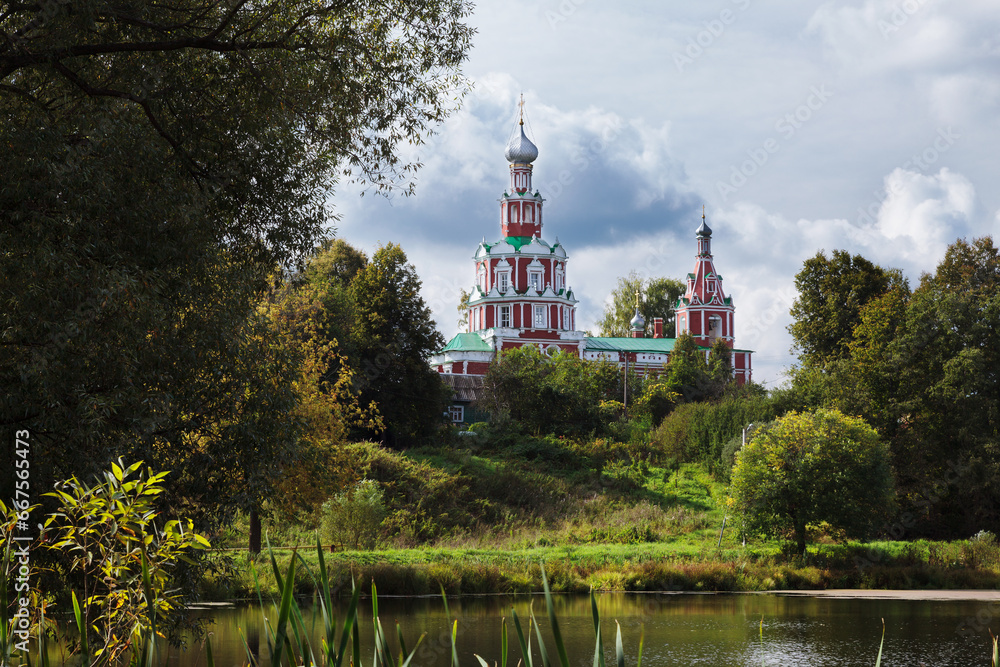 Red orthodox church near lake in Sofrino village, Russia