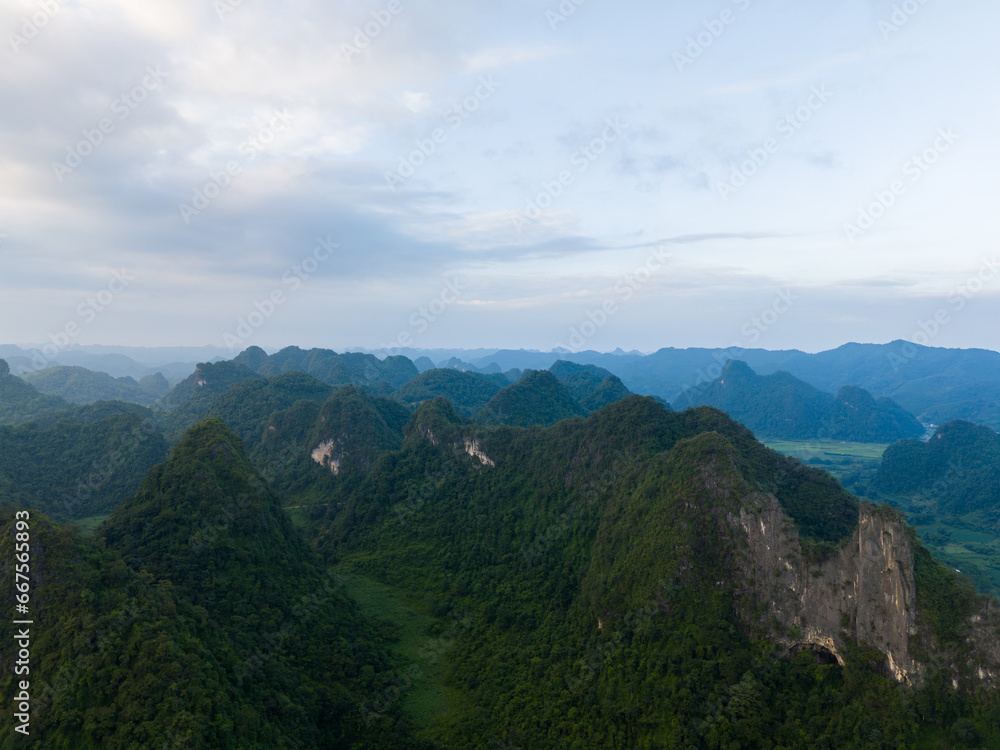 Fototapeta premium Aerial view of Thung mountain in Tra Linh, Cao Bang province, Vietnam with lake, cloudy, nature.