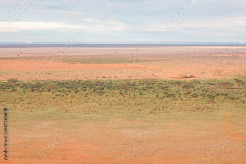 Savannah grassland landscapes with acacia trees and mountains in Tsavo East National Park, Kenya