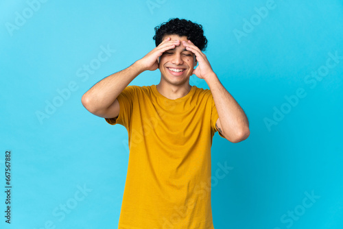 Young Venezuelan man isolated on blue background laughing © luismolinero