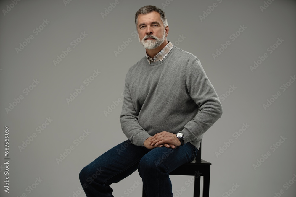 Portrait of a casual senior sitting on a chair on white background Portrait of a casual senior sitting on a chair on white background
