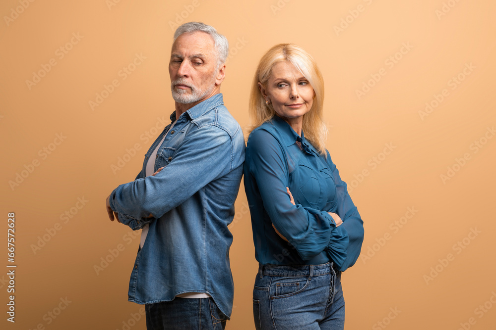 Frustrated senior woman and man couple fighting on beige background Frustrated senior woman and man couple fighting on beige background