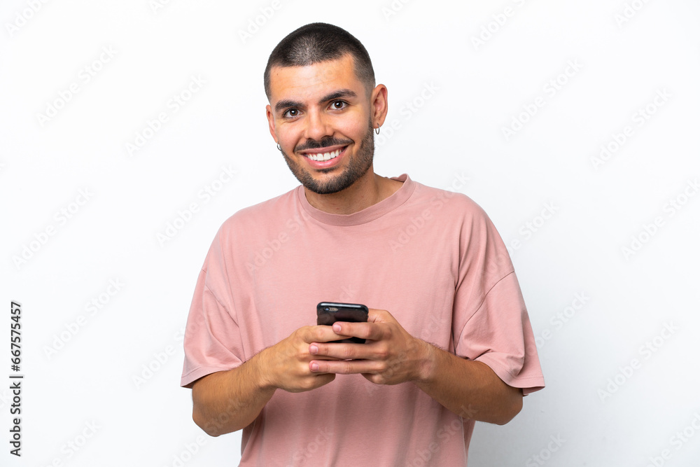 Young caucasian man isolated on white background sending a message with the mobile Young caucasian man isolated on white background sending a message with the mobile
