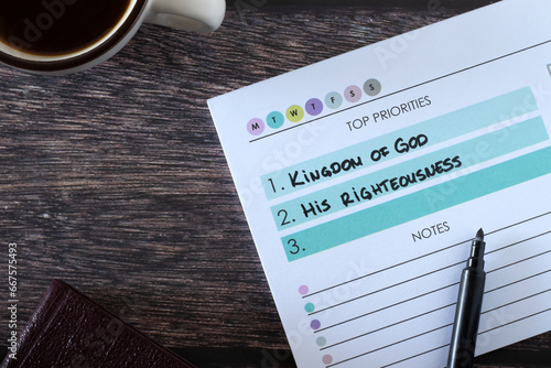 Christian top priorities list, seek first kingdom of God and His righteousness, handwritten text in notebook with cup of coffee and holy bible book on wooden table. Biblical concept.