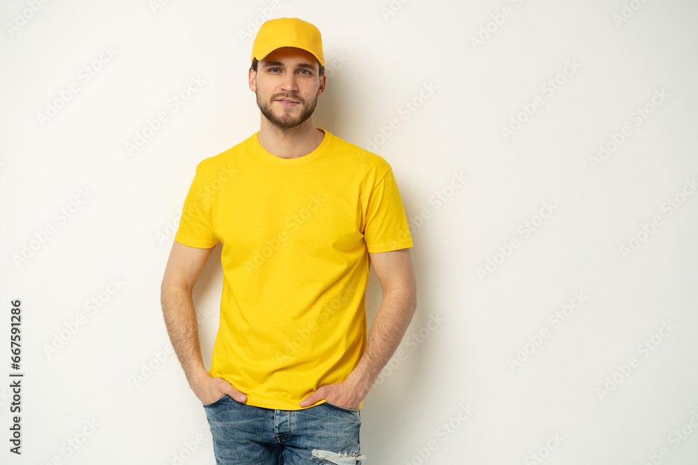 Delivery man in yellow uniform isolated on white background. Professional smiling confident male employee in cap, t-shirt courier dealer