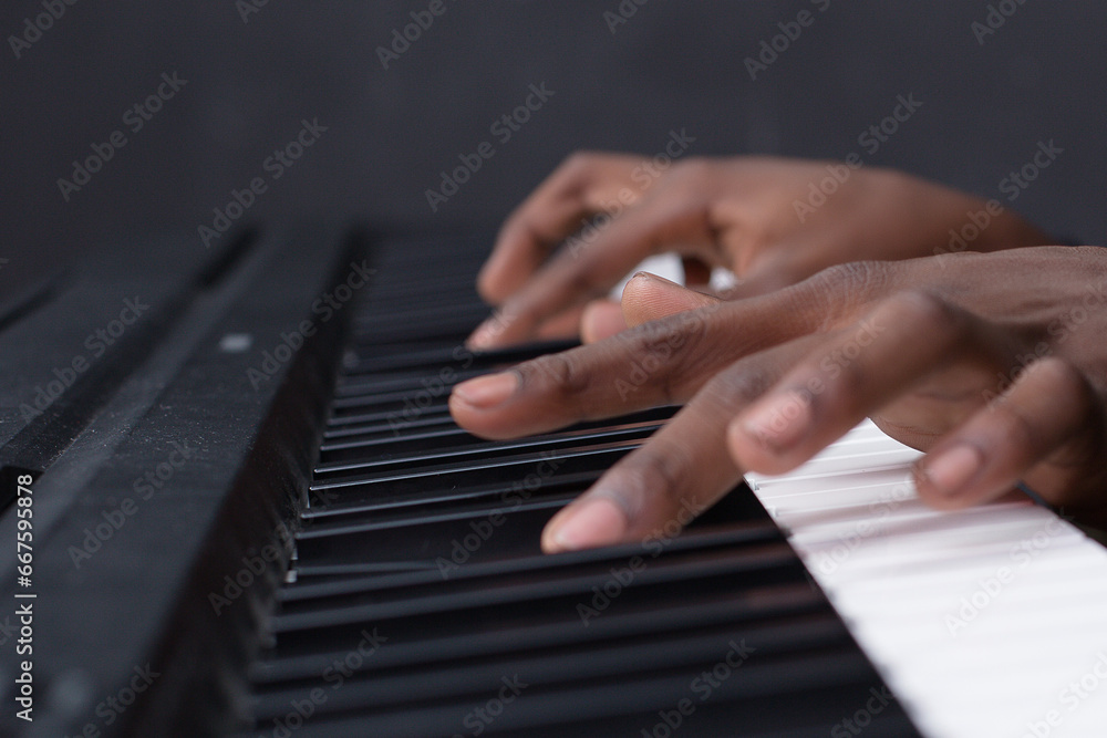 Obraz premium hands of a person playing piano keyboard music pianist in Kenya East Africa fingers on the Keys classical closeup player musical