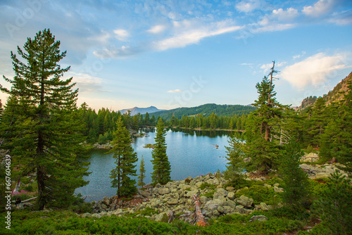 Fototapeta Naklejka Na Ścianę i Meble -  Hridsko Lake - Montenegro's highest mountain lake, a picturesque scene of serene water, towering mountains, lush green forests, and the warmth of summer.