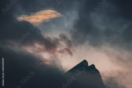 Top of Planspitze Mountain peeking out of the clouds in dusk