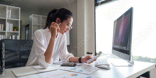 Portrait of beautiful young businesswoman asian sitting at office modern work station and typing on laptop