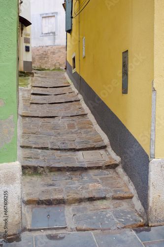 Fototapeta Naklejka Na Ścianę i Meble -  Steep cobblestone narrow passage between houses in an old European town