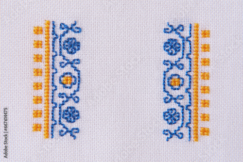 Wallpaper Mural Element of Handmade Embroidery on White Linen by blue and yellow Cotton Threads. Craft Design Torontodigital.ca