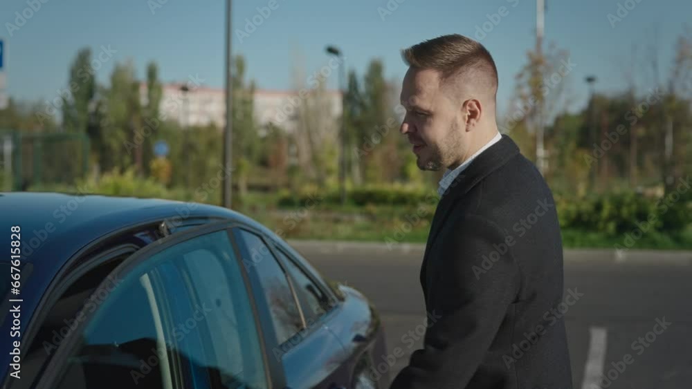 A successful and elegant businessman goes to get into his car. Warm autumn evening in the city. A successful and elegant businessman goes to get into his car. Warm autumn evening in the city.
