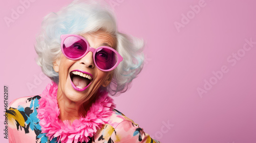 Funny stylish elderly grandmother in glasses poses at studio. Senior old woman looking at camera over bright background.