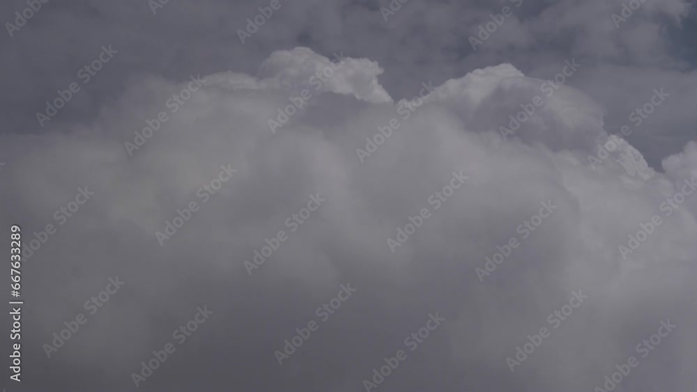 Side view of dense white clouds from an airplane window Side view of dense white clouds from an airplane window