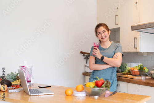 Beauty healthy asian woman making fruit smoothie with blender. woman drinking glass of fruit smoothie in kitchen. Diet concept. healthy drink