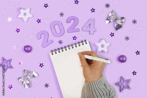 New Year Aims 2024. To Do List. Empty Notebook at the Desk with Holiday Decoration. Top view. Female Hand Creating Plan, Resolution. New Life, Start Up, Beginning Concept. Business idea. Goals, action photo