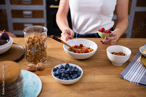 Making healthy breakfast concept granola and berry