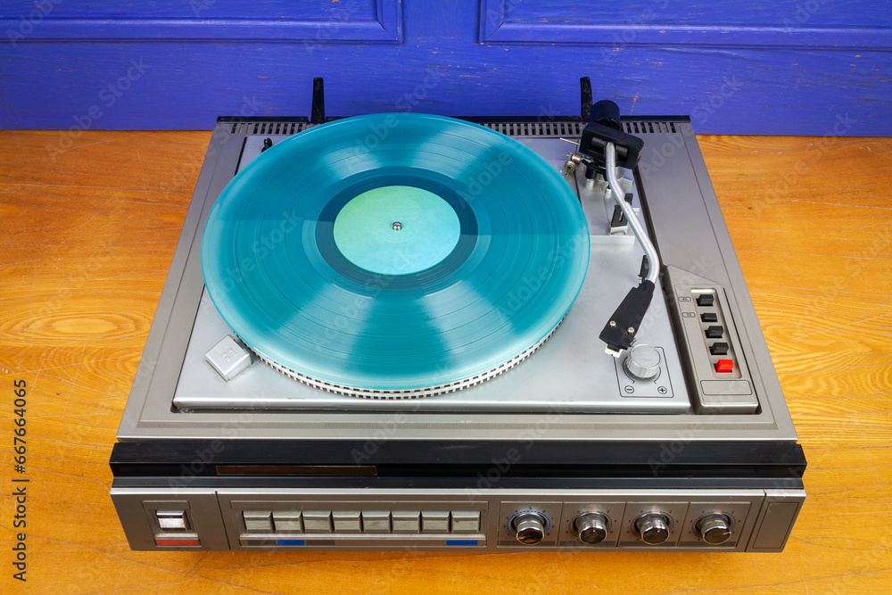 Obraz premium Vintage turntable vinyl record player with turquoise vinyl