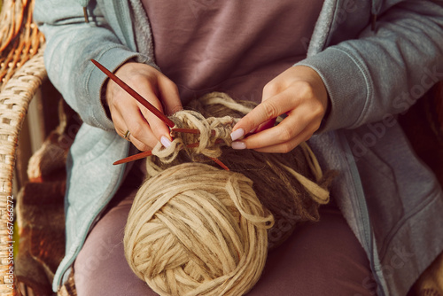 Woman hands knitting with knitting needles and woolen threads close up. DIY background. Cozy autumn warm occupation