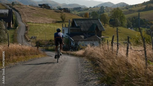 Active male riding bicycle in the mountains. Cyclist rides on a mountain road among high mountains. Ride a bike during a summer heat. Training outdoor. Cycling sport . 