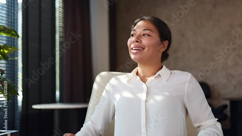 Beautiful multicultural woman in formal blouse closing portable laptop after accomplishing work and relaxing on comfy chair. Female office worker feeling satisfaction and breathing sigh of relief.