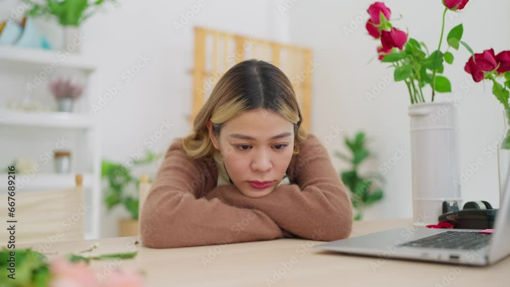 Tired exhausted young Asian woman florist fatigued unmotivated business at flower shop. Woman florist with boredom working burnout. Small business concept Tired exhausted young Asian woman florist fatigued unmotivated business at flower shop. Woman florist with boredom working burnout. Small business concept