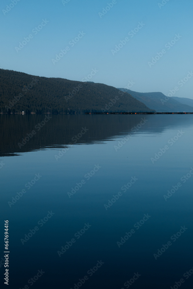 Beautiful view of a mountain and calm water with smooth surface.