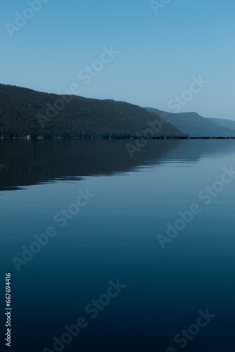 Beautiful view of a mountain and calm water with smooth surface.