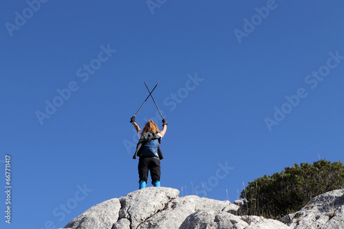 Cheering young woman hiker open arms