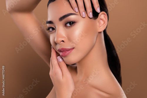 Cosmetology and spa photo of young girl touch her perfect face skin after cleanser isolated on beige color background