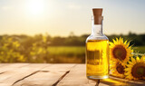 transparent bottle of oil stands on a wooden table on of a field of sunflowers background