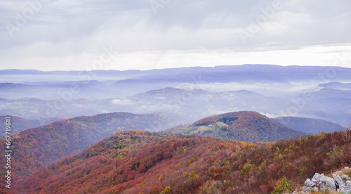 Tranquil mountain landscape with panoramic sky and forest, peaceful nature scene. © mitarart