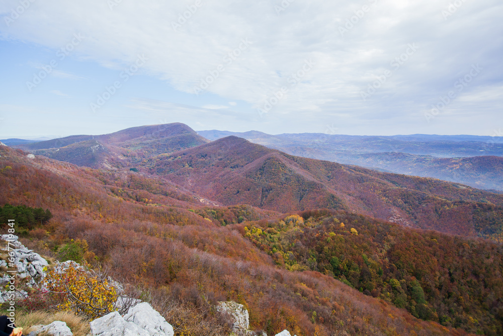 Naklejka premium Tranquil mountain landscape with panoramic sky and forest, peaceful nature scene.