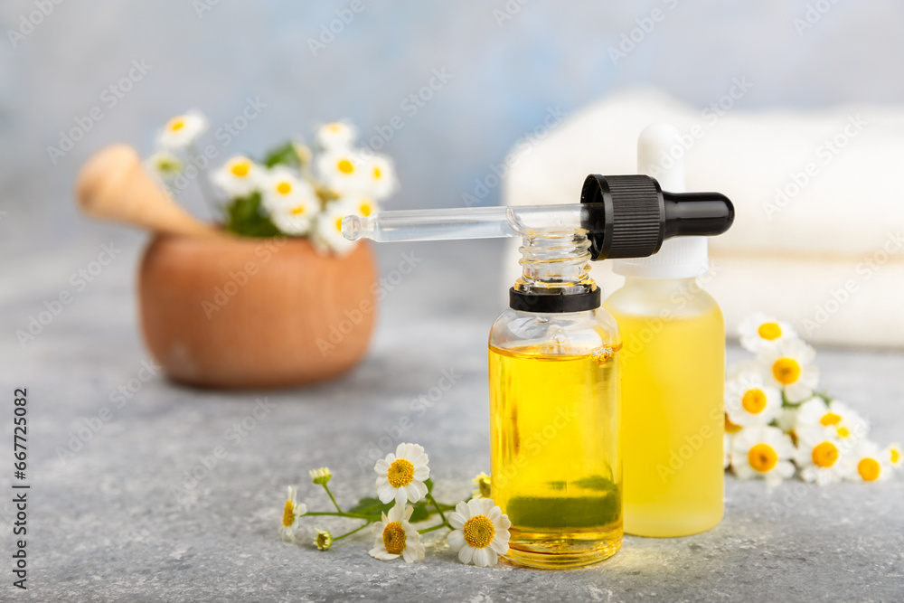 Glass bottle with chamomile essential oil on an old wooden background. Chamomile flowers, close up. Aromatherapy, spa and herbal medicine ingredients. Beauty concept.Copy space. Natural cosmetic Glass bottle with chamomile essential oil on an old wooden background. Chamomile flowers, close up. Aromatherapy, spa and herbal medicine ingredients. Beauty concept.Copy space. Natural cosmetic