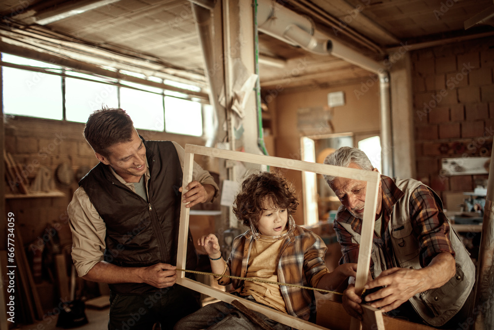 Three Generations of Carpenters : Grandfather, Father, and Son working in the Workshop