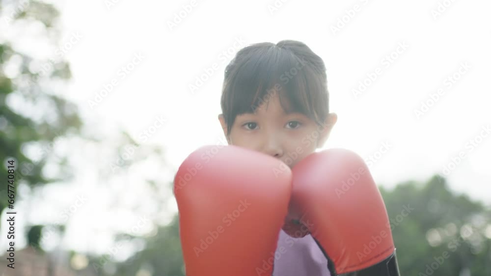 A little girl is boxing and exercising in the garden. A little girl is boxing and exercising in the garden.