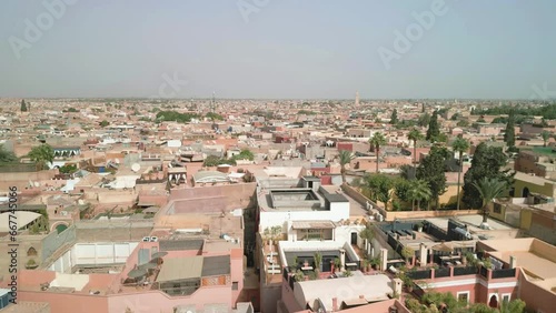 Medina of Marrakesh, Morocco. Aerial view of the old city and mosques. Cinematic drone footage going downward. Famous tourist destination. Landmark touristic town of Marrakech, North Africa.