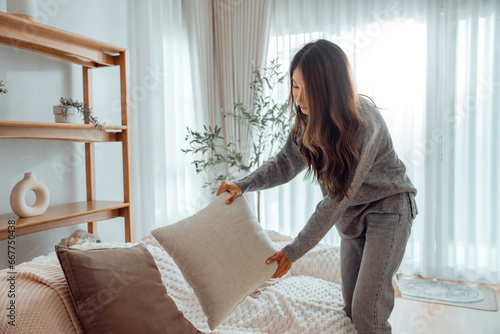 Foto Asian woman arranging pillows on comfortable sofa cushions at home, household, h
