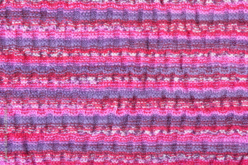 Abstract knitted colorful background. Wave pattern of pink, blue, yellow, purple knitting threads. Close-up of a knitted blanket. Copy space